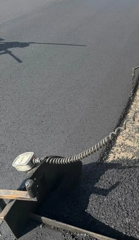Close detail of asphalt meeting an unfinished gravel edge